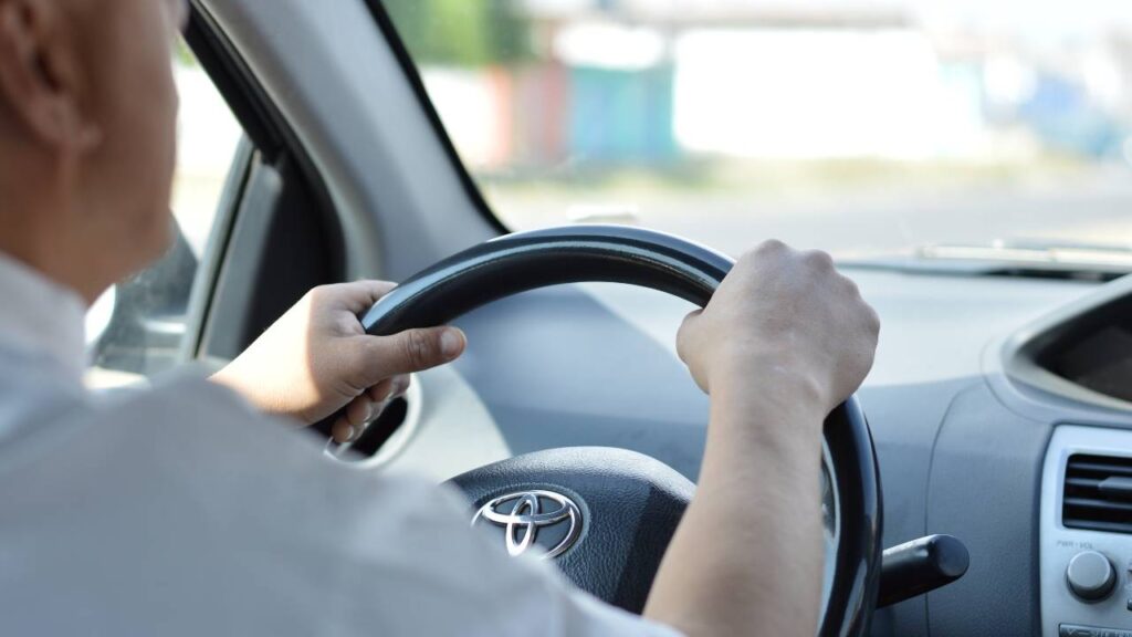 Chauffeur's hands on a steering wheel  of a car