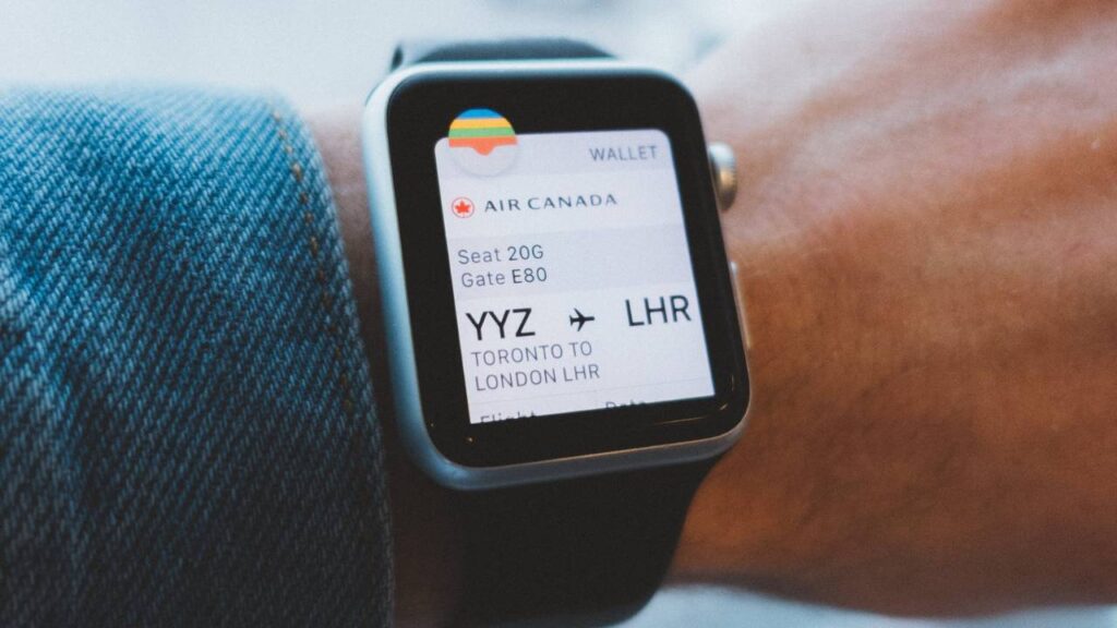 Smartwatch on a wrist showing an upcoming flight
