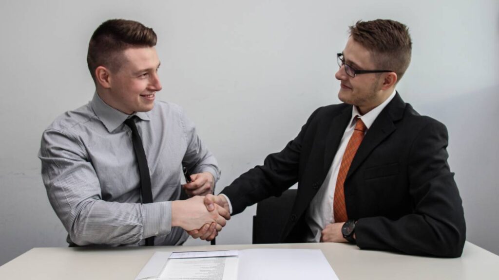 Two businessmen shaking hands and smiling