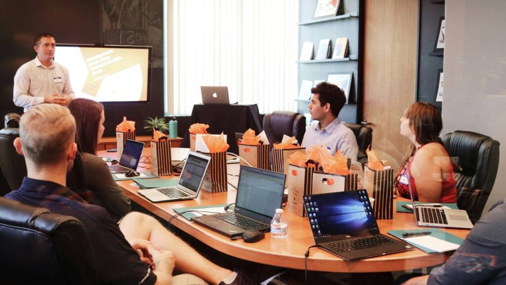 Workers listening to a man speaking in the conference room